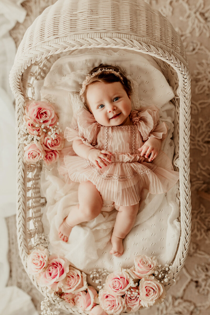 4 Month old baby in a white wicker bassinet with pink roses, OKC family photographer.