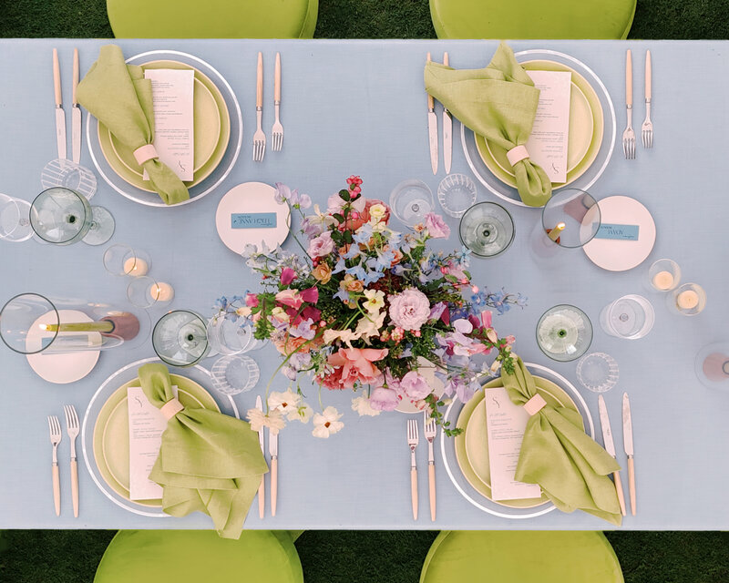 Beautiful shot of a tablescape from above with our chartreuse dinner plates, and our clear white rim chargers, and our glassware. 