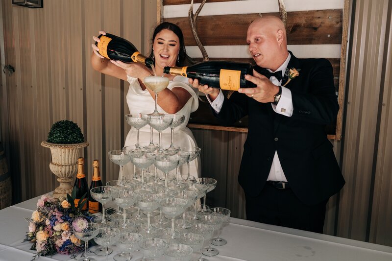 a bride and groom pour veuve champagne tower during wedding at darfield