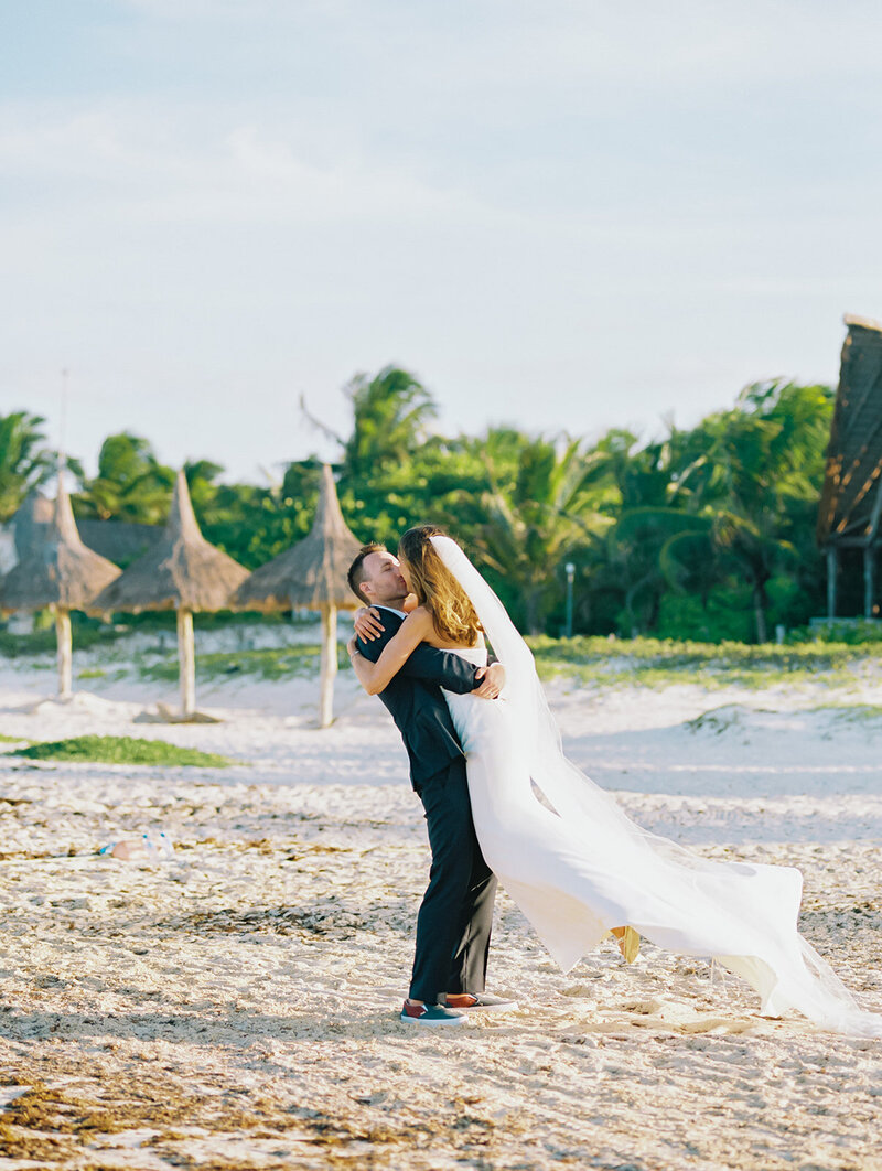 Bride and groom kiss at a beach destination wedding