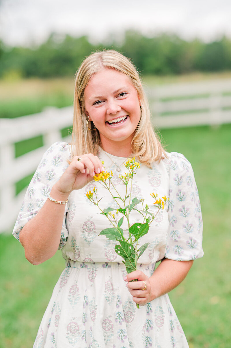a girl smiling while holding flowers