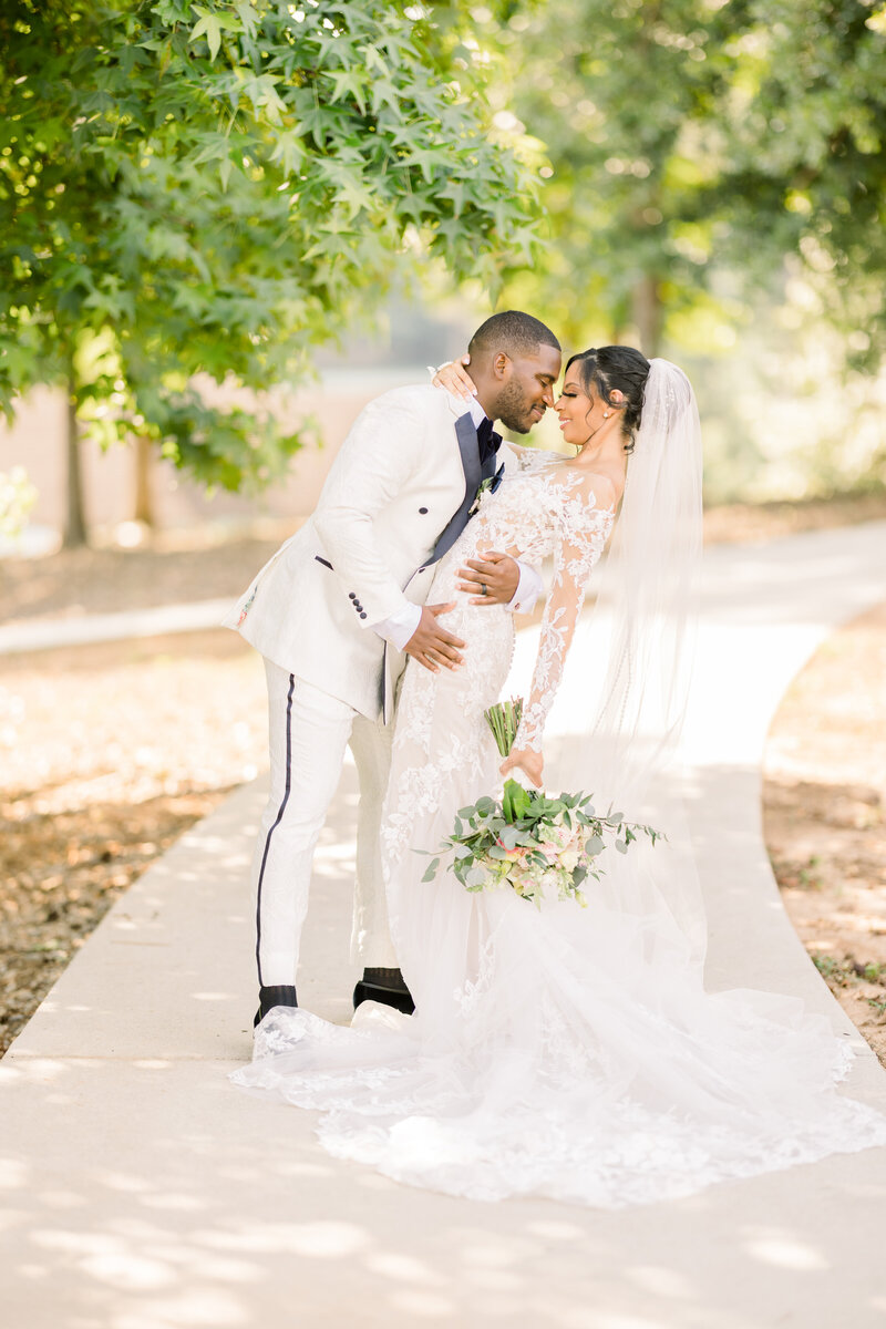 Bride and groom walking hand in hand, celebrating their wedding day with elegance and emotion in a picturesque outdoor setting.