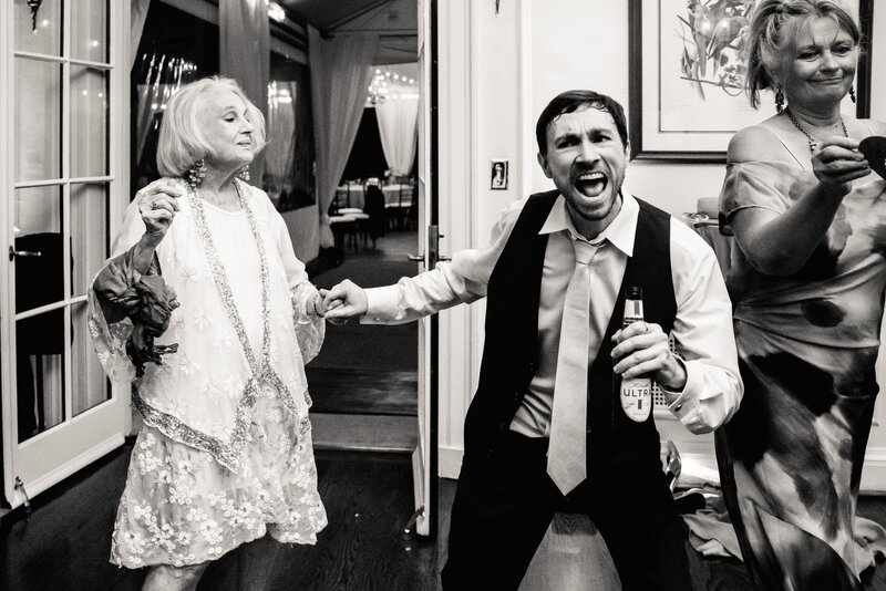 A groom dances with his grandmother on the dance floor