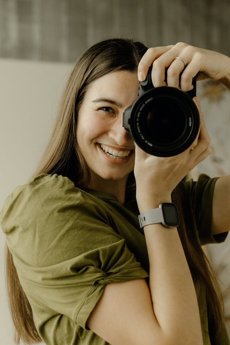 Playful headshot of Cedar Rapids wedding photographer with her camera