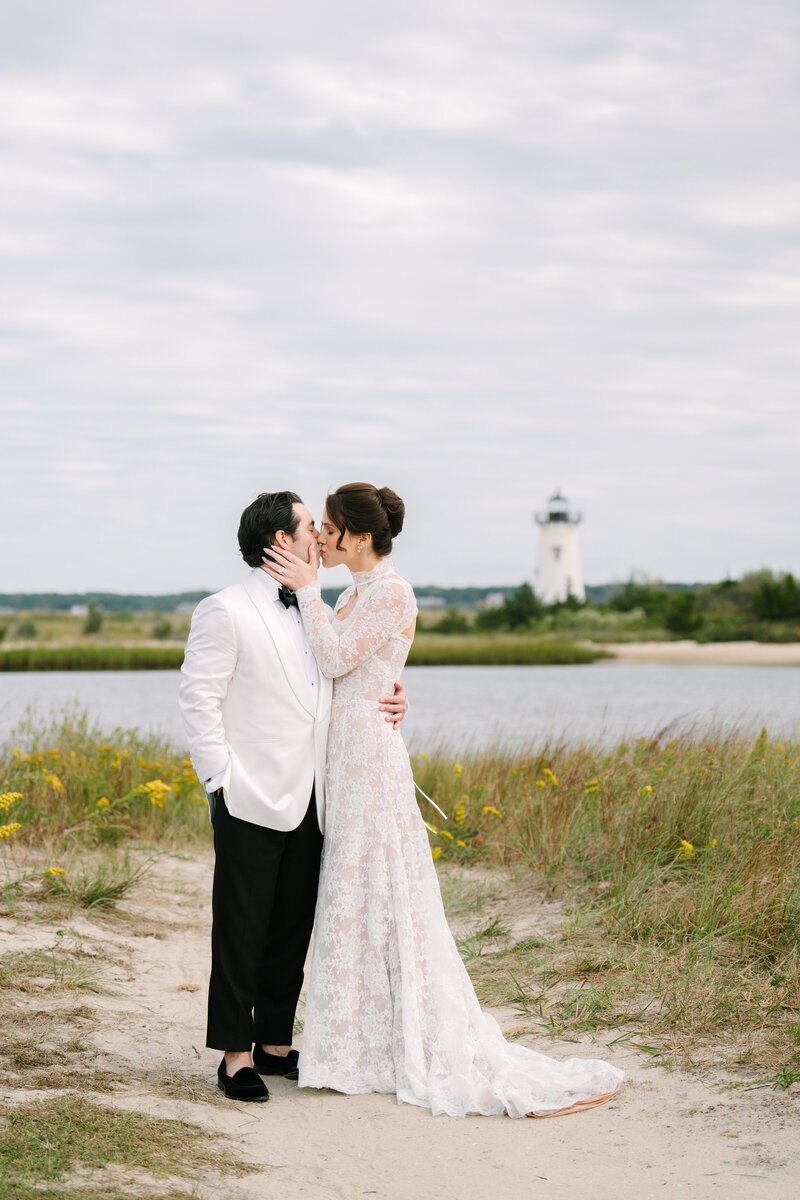bride and groom kissing in front of the Edgartown lighthouse during their atria marthas vineyard wedding