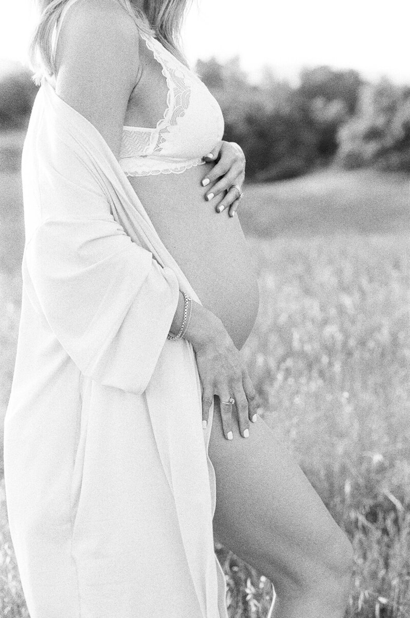 Pregnant woman standing in a field of flowers