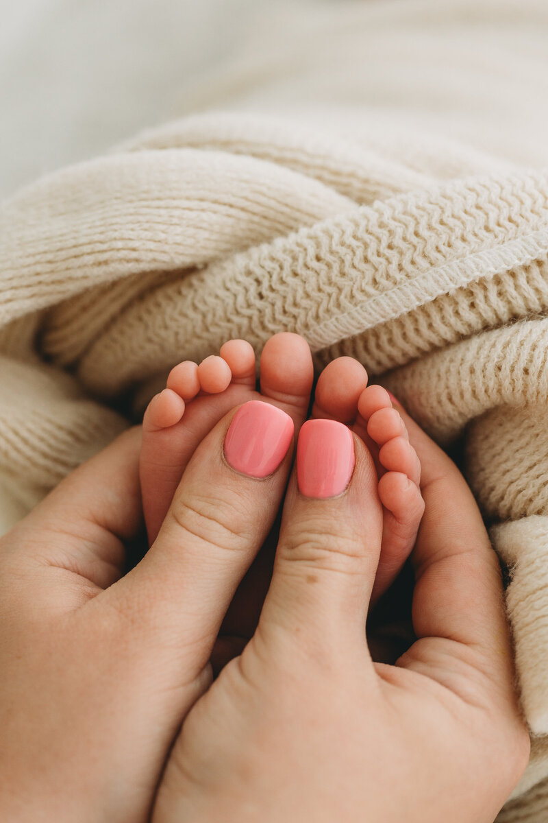 Kelowna BC Newborn session in Studio of mom holding baby's feet and the ten toes are sticking out