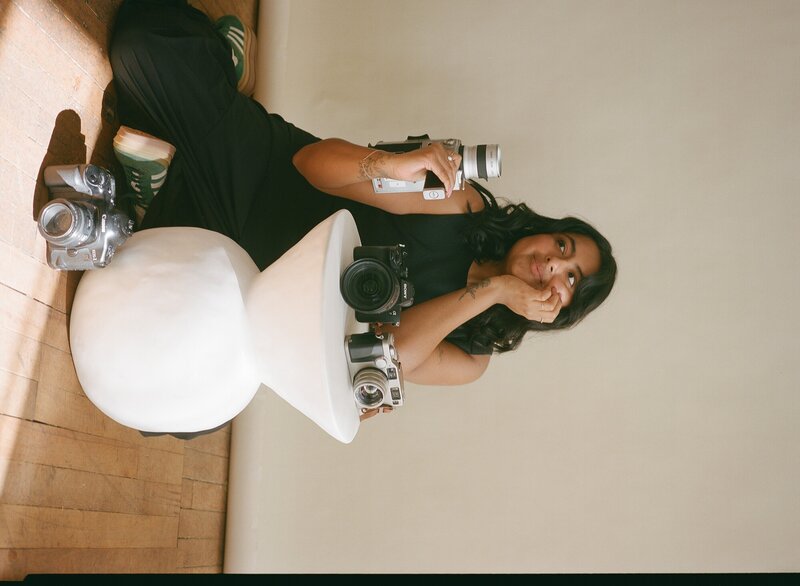California wedding photographer holding a camera in a studio back drop photo.