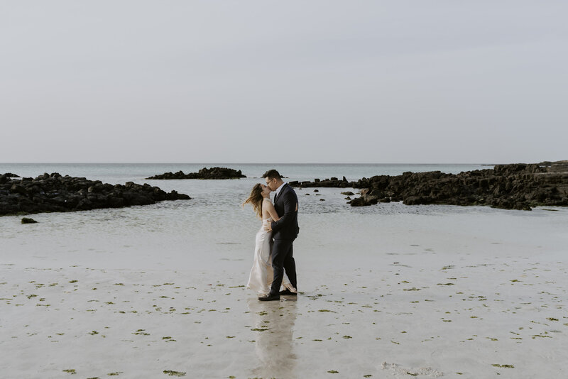 happy couple kissing on a beach in jeju island