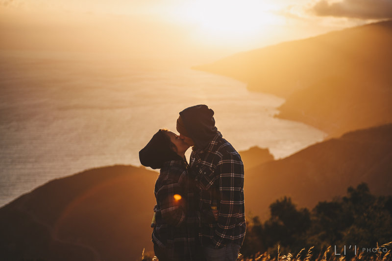 Couple kissing at sunset by the ocean shore