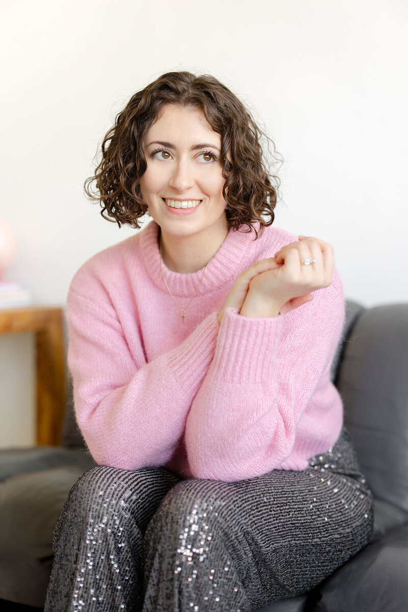 Emily shakes her head while laughing as her curly shoulder length hair whips around