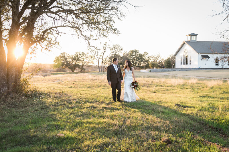 bride and groom in front of a church at sunset