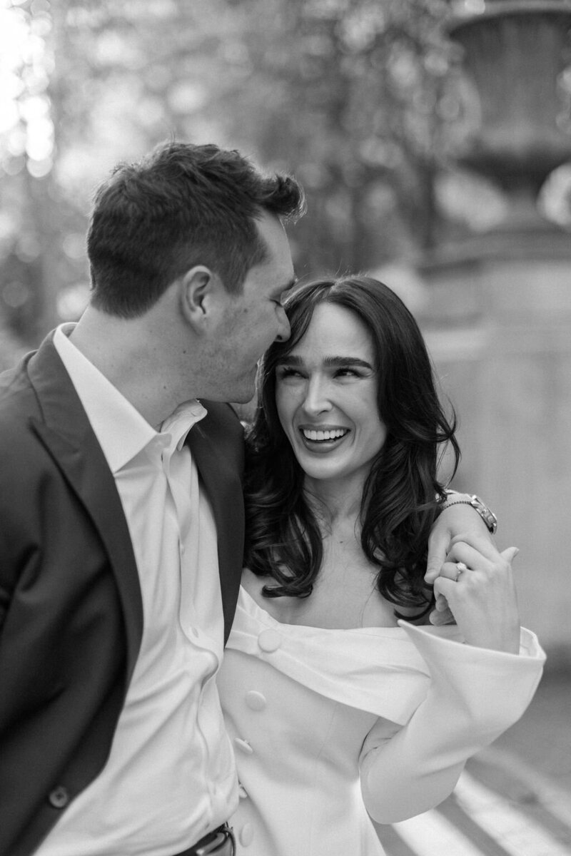 Bride and groom smile at each other crossing street in New York