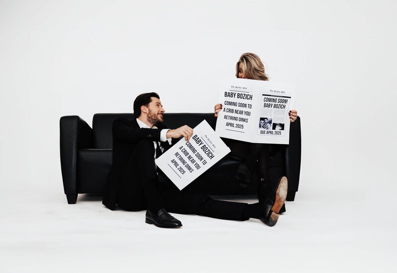 Couple Announcing Pregnancy With Baby Newspaper Signs