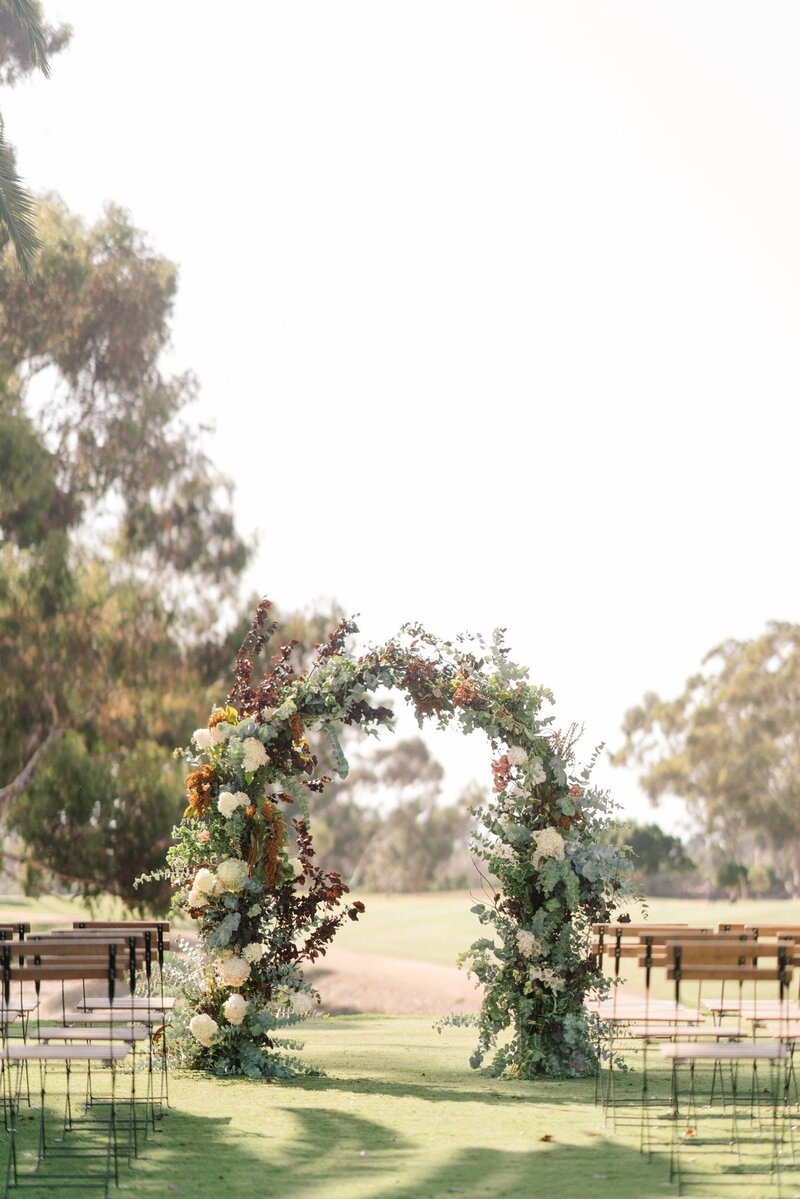 A lush floral arch at a Holman Ranch summer wedding