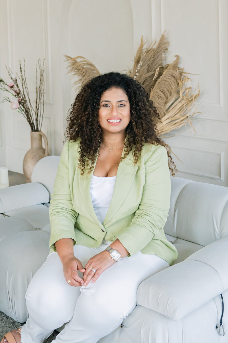 woman smiling at the camera while sitting on a couch