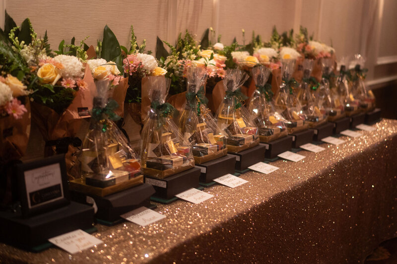 Sparkly tablecloth with awards lined up on a table with flowers for the  Business Excellence Awards in Stratford Ontario