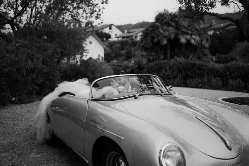 wedding couple doing portraits on a vintage luxury car in Italy