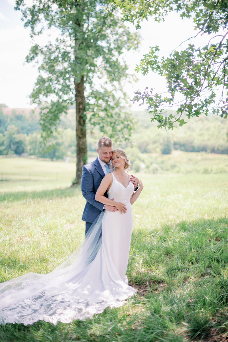 Bride and groom pose for wedding portraits taken by best Greenville wedding photographers Kayla Nelson Photography at Arran Farms wedding venue.