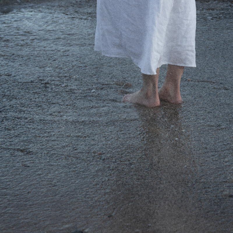 woman standing in ocean water, grounding.