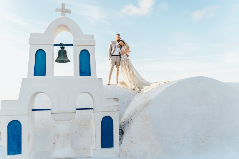 bride and groom standing on rooftop in Greece