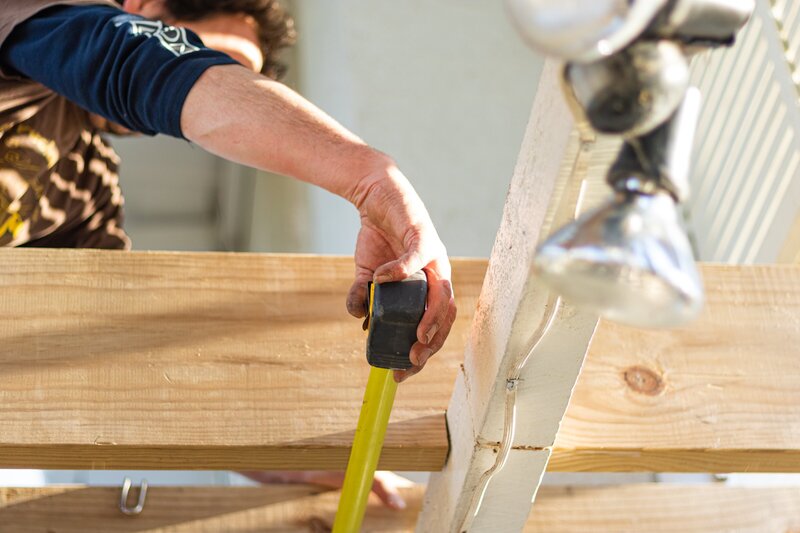 builder measuring wooden beams