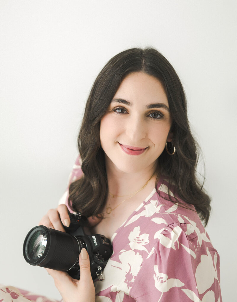 Photographer in Kentucky holding camera and smiling at camera. 