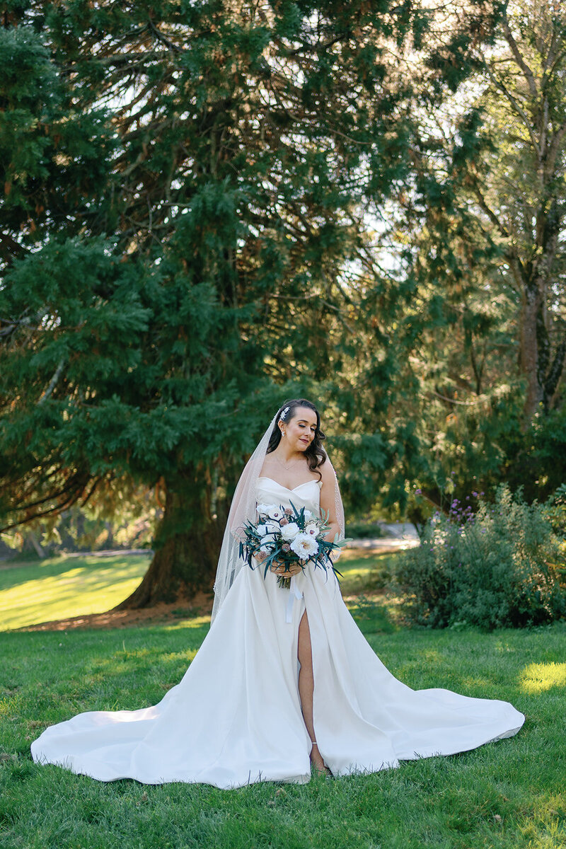 Bride in a strapless gown holding a white and blush bridal bouquet