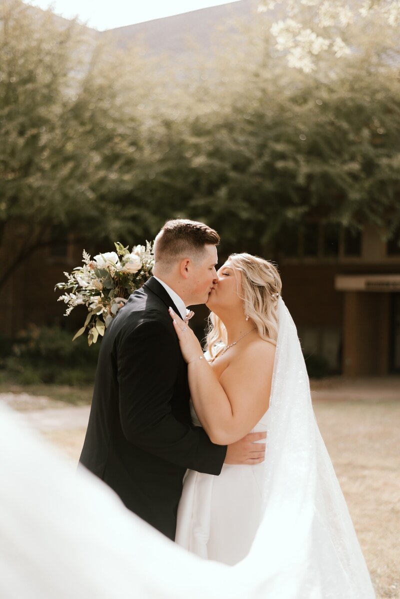 bride and groom share a kiss on wedding day in peoria il