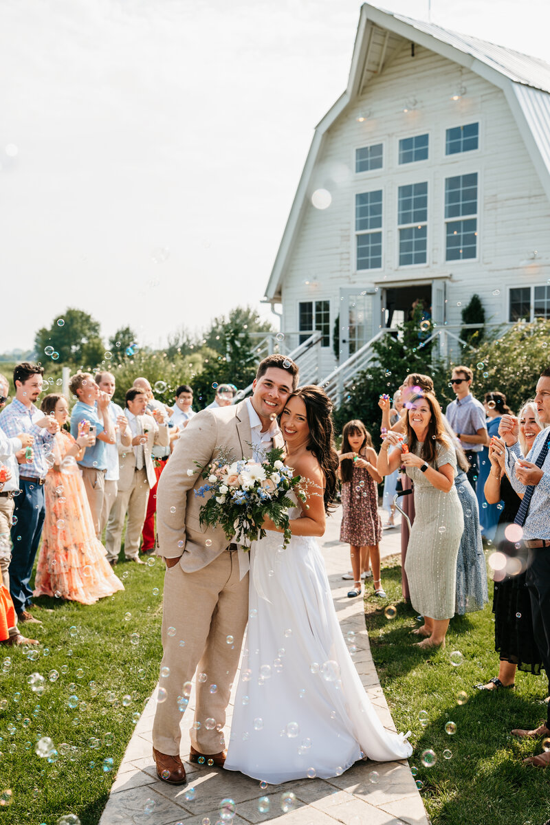 Wedding couple walking through bubbles and smiling in Minnesota