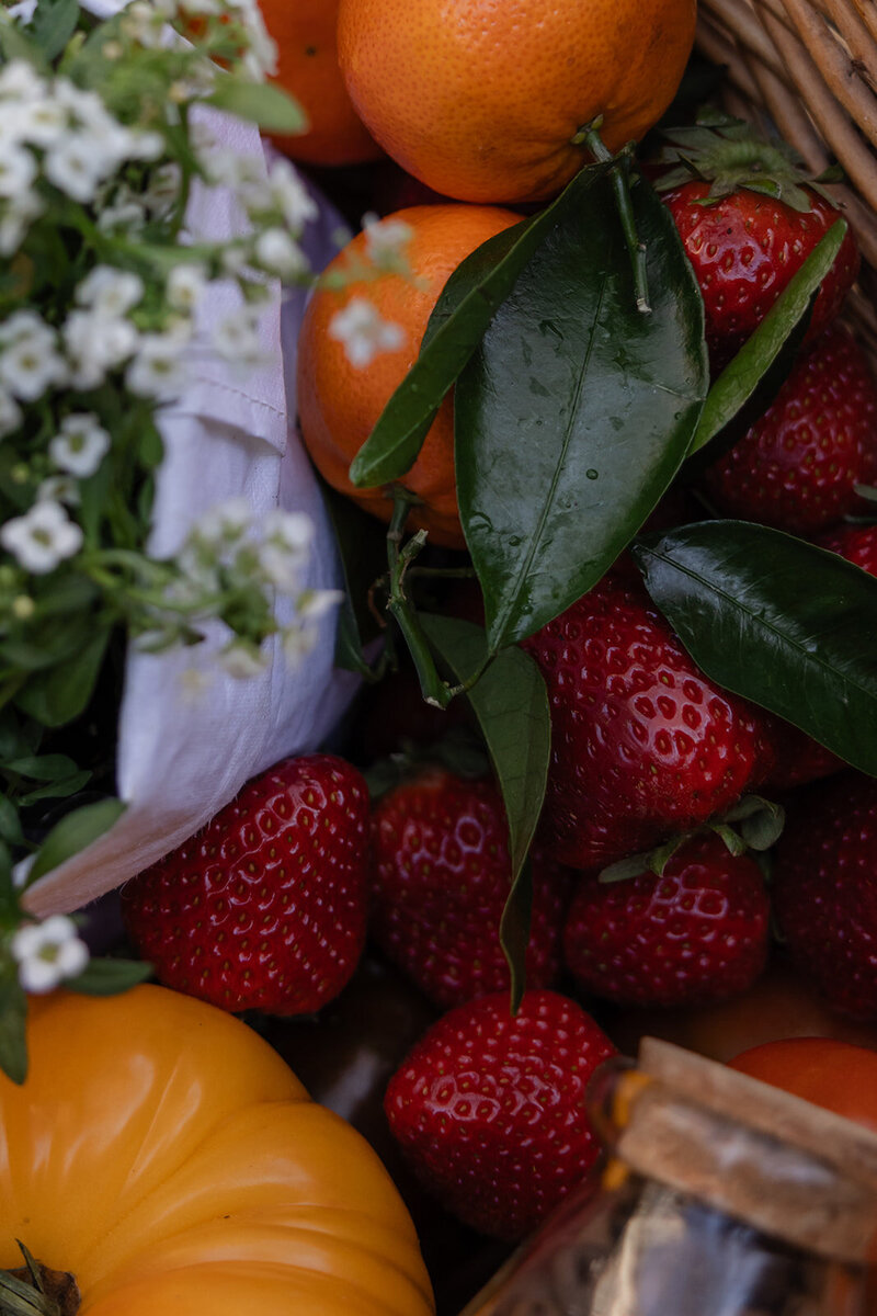 Close-up of seasonal strawberries, mandarin oranges, and baby’s breath styled to reflect natural nourishment and beauty