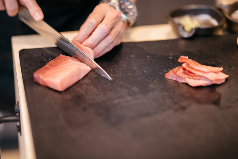 Sushi chef cutting sashimi