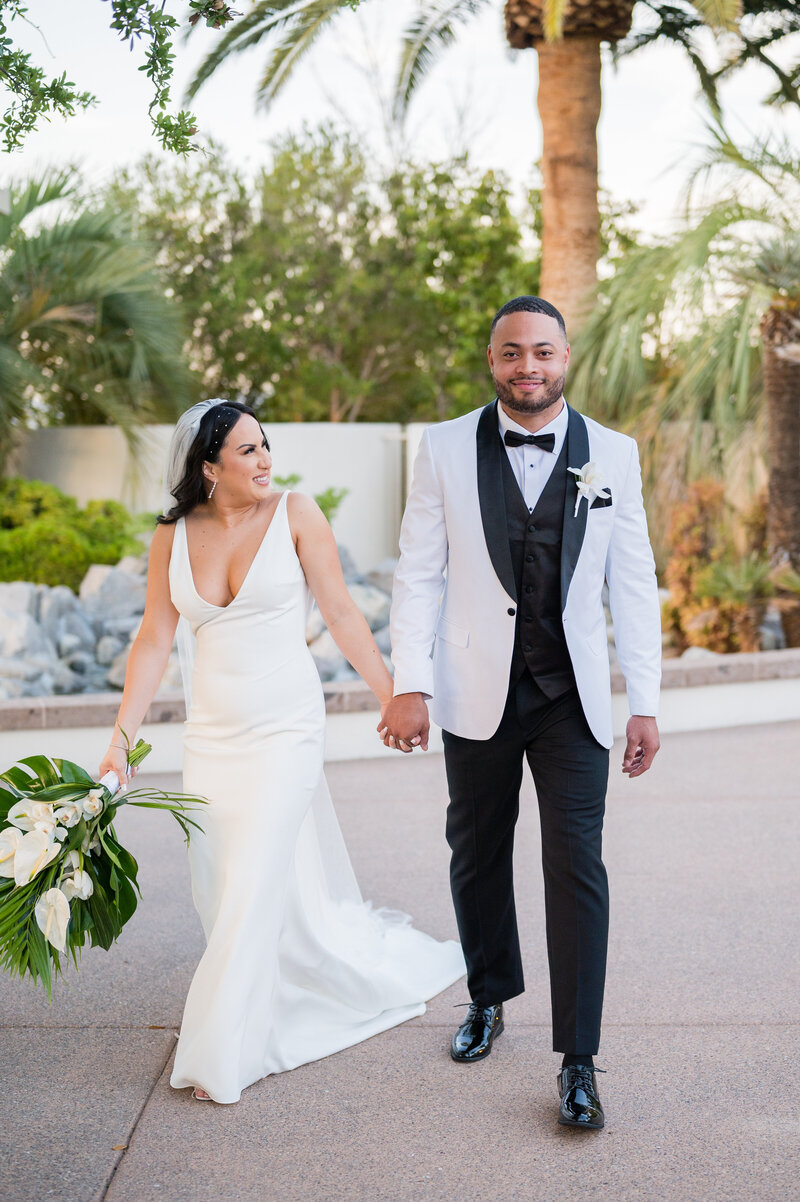 Bride and groom sharing a romantic moment by the pond at Emerald at Queensridge.