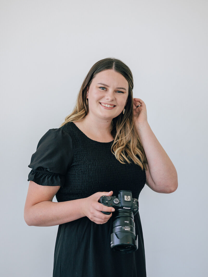 woman smiling while holding camera