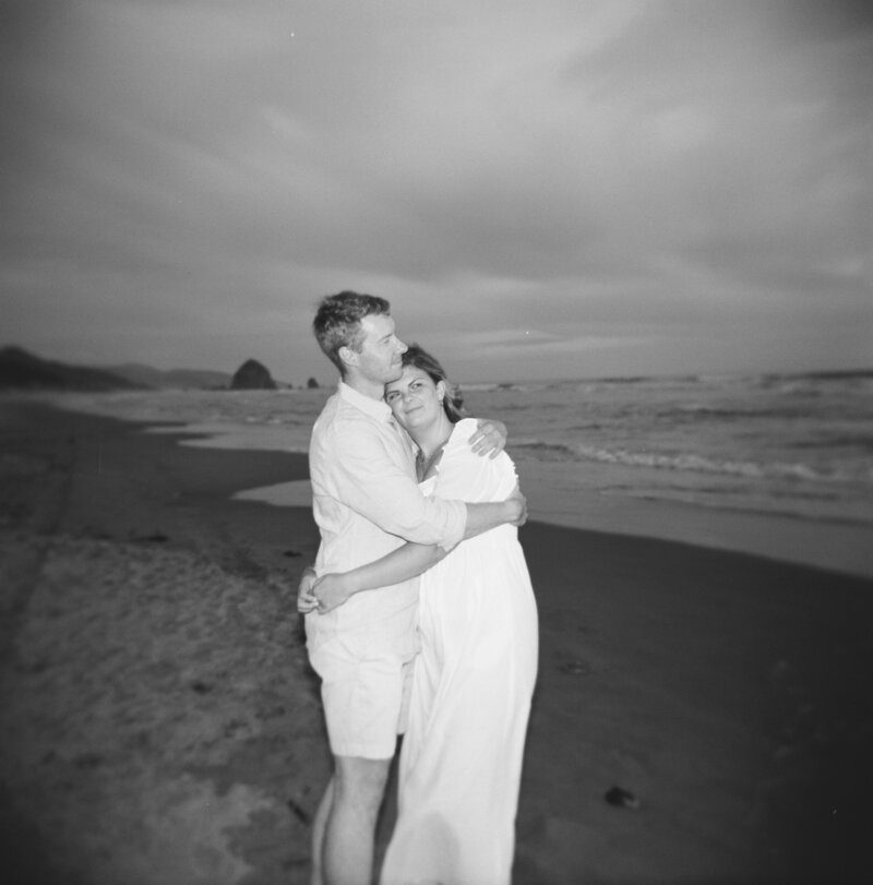 couple holding each other at cannon beach