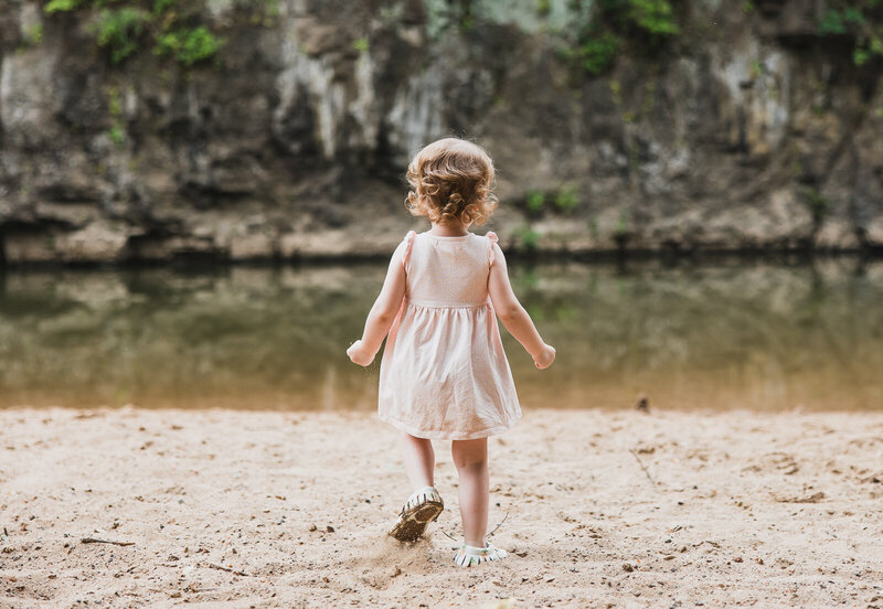 Toddler girl running toward the creek. 