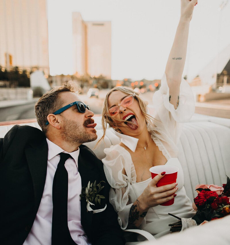 bride and groom partying in back of vintage car