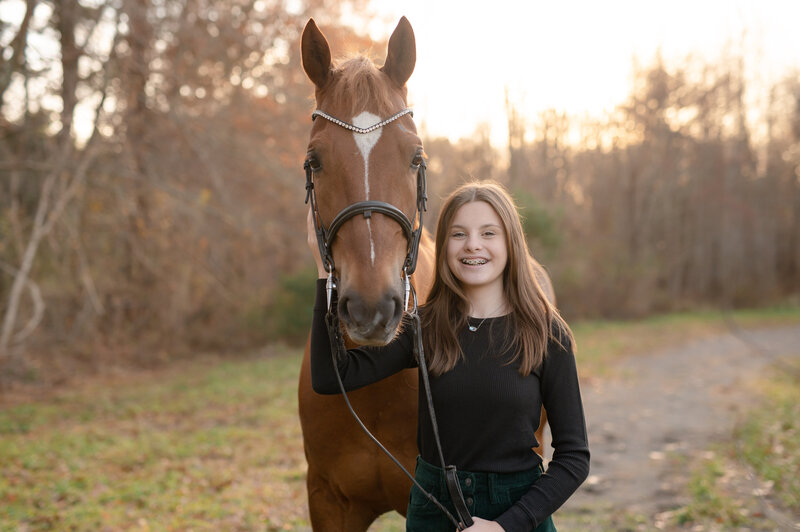 girl touching horse smiling at camera