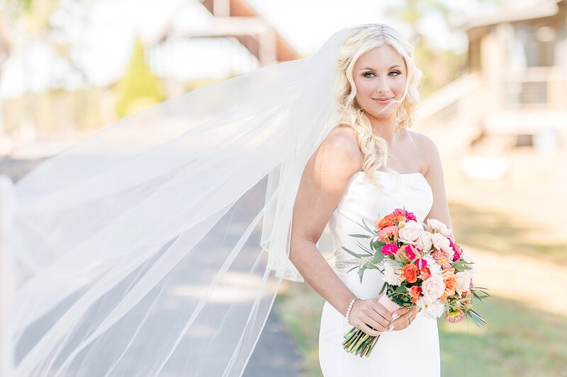 Bride with pink and orange florals | New Water Farms Wedding Photography