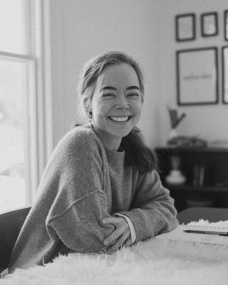 Dr. Tanner Wallace, founder of CPTSD Medicine, smiling at her desk while guiding students in trauma healing and Self Study.