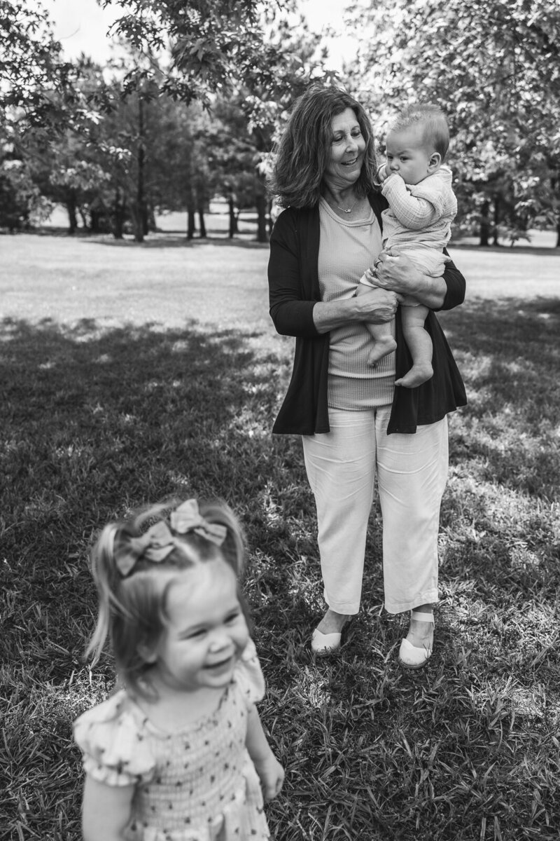 Black and white portrait of a grand mother playing with her two grandchildren. 