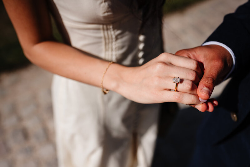 He and her looking at the engagement ring on her right hand.