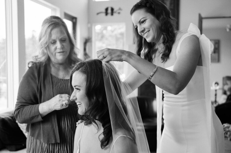 Bride's sister and mother help with her veil