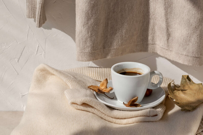 Cup of coffee on sweater, symbolizing a moment of rest and intentional reflection 