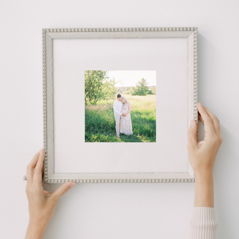 A framed and matted fine art print is held by Kahla Kristen Photography
