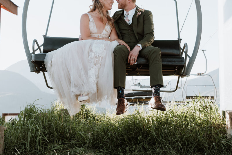 Bride and groom share quiet moment on ski lift after mountain wedding in Breckenridge, Colorado.