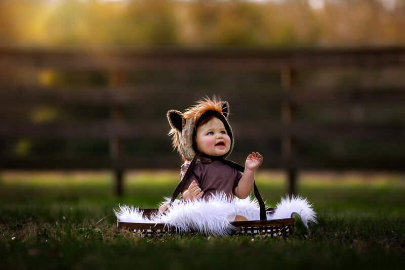 Adorable sitter baby wearing a horse bonnet while sitting inside. basked, photographed by Houston family photographer  Danielle Dott photography.