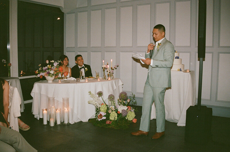 Bride and groom seated at a sweetheart table with floral arrangements, candles, and elegant décor, styled by Yours Truly, a wedding planner and designer in New Jersey.