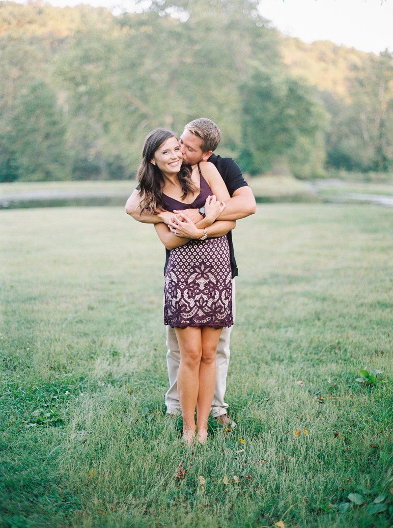 man kissing a woman on the cheek while they hug