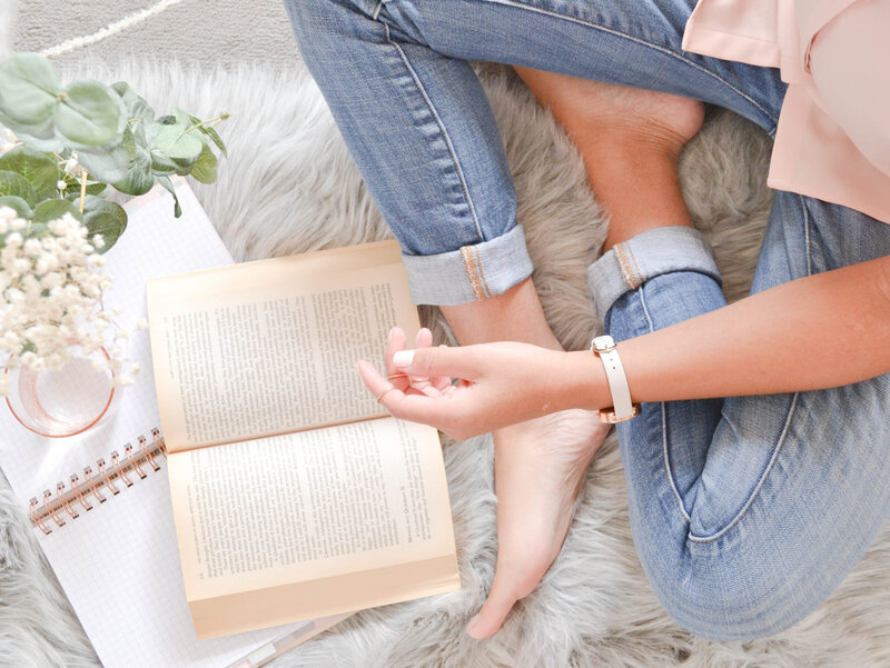 Woman  wearing jeans sitting reading a book